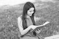 Read and look what great things are in book. Happy girl read book on park bench. Small reader on summer outdoor. Read