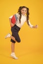 Reader rushing for books. Happy little girl holding books with colorful covers on yellow background. Cute small child Royalty Free Stock Photo