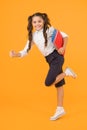 Reader rushing for books. Happy little girl holding books with colorful covers on yellow background. Cute small child Royalty Free Stock Photo