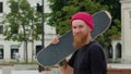 Readhead hipster in hat with a skateboard