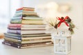 A pile of books in the background and lantern in front of it.