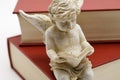 Reading angel sitting on a book Royalty Free Stock Photo