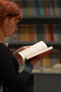 Reading book close up view of a woman red hair profile hand holding an open book Royalty Free Stock Photo