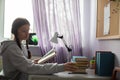 While reading a book at her desk, the girl reached for an apple.