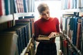 Student reading a book in library Royalty Free Stock Photo