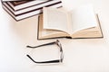 Spectacles and open book near stack of books Royalty Free Stock Photo