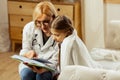 Charming doctor reading a book with cute sick little girl