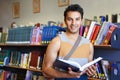 Reading book, portrait or happy man in library at university, college or school campus for education. Bookshelf Royalty Free Stock Photo