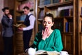 Reading book and study poetry. woman in library read book at teapot drinking coffee from cup. literature cafe with cute Royalty Free Stock Photo