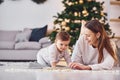 Reading book together. Mother with her little daughter is indoors at home together Royalty Free Stock Photo