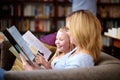 Reading, books and mom with child in library with smile, learning and relax, studying and knowledge. Storytelling, happy Royalty Free Stock Photo