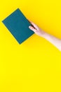 Reading concept. Reading as hobby. New knowledge. Hands take hardback book with empty cover on yellow background top Royalty Free Stock Photo