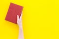 Reading concept. Reading as hobby. New knowledge. Hands take hardback book with empty cover on yellow background top Royalty Free Stock Photo