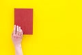 Reading concept. Reading as hobby. New knowledge. Hands take hardback book with empty cover on yellow background top Royalty Free Stock Photo