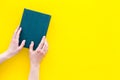 Reading concept. Reading as hobby. New knowledge. Hands take hardback book with empty cover on yellow background top Royalty Free Stock Photo