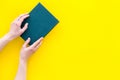 Reading concept. Reading as hobby. New knowledge. Hands take hardback book with empty cover on yellow background top Royalty Free Stock Photo