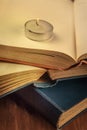 Reading in the dark by candlelight. A stack of old books with a burning candle Royalty Free Stock Photo