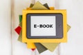 Reading. E-book reader is on top of a stack of books on a wooden background. Flat lay. Concept of education and electronic gadgets Royalty Free Stock Photo