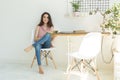 Reading, education, culture, people concept - young student woman is reading a book, while she is sitting on white chair