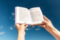 close up of hands holding open book over blue sky Royalty Free Stock Photo