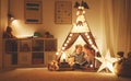 Mother and child daughter reading a book and a flashlight before Royalty Free Stock Photo