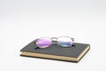 Reading glasses on black book isolated on white background Royalty Free Stock Photo