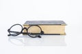 Reading glasses with old book on white background Royalty Free Stock Photo