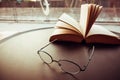 Reading glasses on table with open book Royalty Free Stock Photo