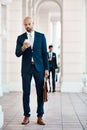Reading his emails conveniently on the way to work. a young handsome businessman using a cellphone outside. Royalty Free Stock Photo