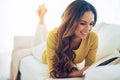 Reading keeps me fully awake and alive. a young woman reading a book while relaxing at home.