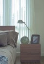 Reading lamp, clock and picture frame on bedside table Royalty Free Stock Photo