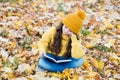 Reading really matters. Little child read book sitting on fall leaves. School library. Knowledge and informaiton