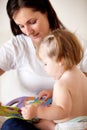 Reading with mom. A young mother showing her daughter pictures in a book. Royalty Free Stock Photo