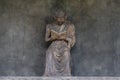 A reading monk statue with day light