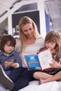 Reading, mother and children on sofa with book for bonding, teaching and learning together in home. Woman, son and Royalty Free Stock Photo