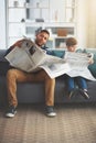 Reading the newspaper like a big boy. a carefree little boy and his father reading the newspaper while being seated on Royalty Free Stock Photo