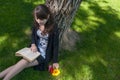 Reading in the park. Cute girl sitting on grass and read an old book Royalty Free Stock Photo