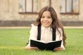 Reading is passport to world. Happy little girl enjoy reading book on green grass. Cute small child learn reading at Royalty Free Stock Photo