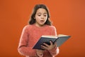 Reading practice for kids. Childrens literature. Girl hold book read story over orange background. Child enjoy reading Royalty Free Stock Photo