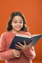 Reading practice for kids. Girl hold book read story over orange background. Child enjoy reading book. Book store Royalty Free Stock Photo