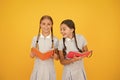 Reading and retelling. Small children holding books yellow background. Sincere interest. Little girls with encyclopedia Royalty Free Stock Photo