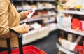 Reading shopping list in supermarket. Female customer. Royalty Free Stock Photo