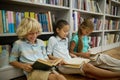 Boy and two girls sitting on floor reading books Royalty Free Stock Photo