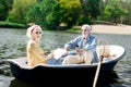 Happy elderly woman reading book during amazing boat ride with her man