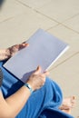 unrecognizable woman holding blank magazine for mockup design, sitting by the swimming pool Royalty Free Stock Photo