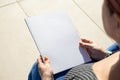 unrecognizable woman holding blank magazine for mockup design, sitting by the swimming pool Royalty Free Stock Photo