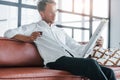 Reads newspaper. Caucasian young guy in elegant white shirt indoors at home Royalty Free Stock Photo