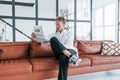 Reads newspaper. Caucasian young guy in elegant white shirt indoors at home Royalty Free Stock Photo