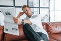 Reads newspaper. Caucasian young guy in elegant white shirt indoors at home Royalty Free Stock Photo