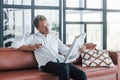 Reads newspaper. Caucasian young guy in elegant white shirt indoors at home Royalty Free Stock Photo